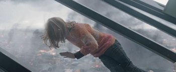 Movie still from “The Quake” (2018), directed by John Andreas Andersen – A woman in a sweater is standing on a glass floor; Medium shot, Overhead angle