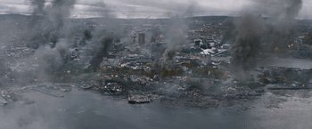 Movie still from “The Quake” (2018), directed by John Andreas Andersen – An aerial view of a city with smoke billowing out of it; Extreme Wide shot, High angle