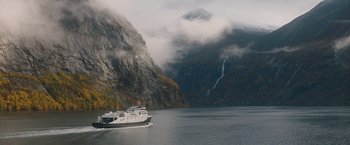 Movie still from “The Quake” (2018), directed by John Andreas Andersen – A boat in a body of water near a mountain; Extreme Wide shot, High angle