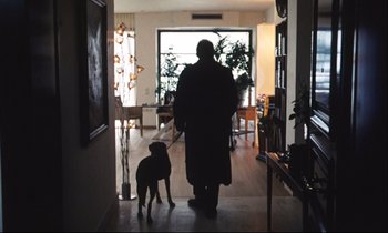 Movie still from “Eternity and a Day” (1998), directed by Theodoros Angelopoulos – A man and a dog are walking in a room; Wide shot, Low angle