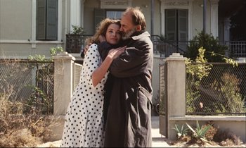 Movie still from “Eternity and a Day” (1998), directed by Theodoros Angelopoulos – A man and a woman embracing each other outside; Medium shot, Low angle