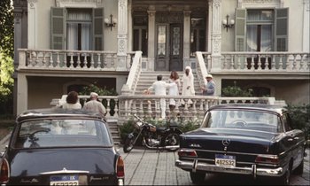 Movie still from “Eternity and a Day” (1998), directed by Theodoros Angelopoulos – A group of people standing on the side of a building; Extreme Wide shot, High angle