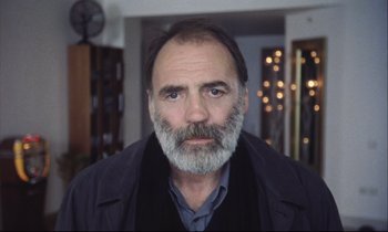 Movie still from “Eternity and a Day” (1998), directed by Theodoros Angelopoulos – A person with a gray beard; Close Up shot, Low angle