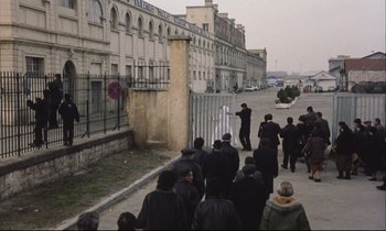 Movie still from “Eternity and a Day” (1998), directed by Theodoros Angelopoulos – A group of people walking down a street; Extreme Wide shot, High angle