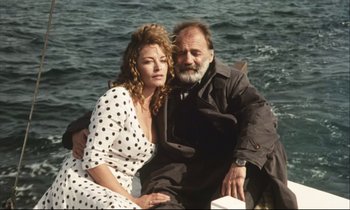 Movie still from “Eternity and a Day” (1998), directed by Theodoros Angelopoulos – An older man sitting next to an older woman on a boat; Medium shot, Low angle