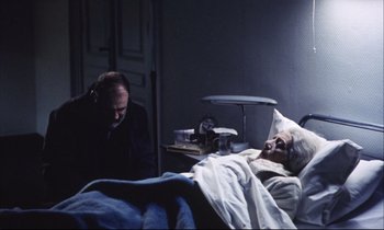 Movie still from “Eternity and a Day” (1998), directed by Theodoros Angelopoulos – An old man laying in a hospital bed next to an older man; Medium shot, High angle