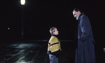 Movie still from “Eternity and a Day” (1998), directed by Theodoros Angelopoulos – A man standing next to a young boy in the dark; Medium shot, Over the shoulder angle