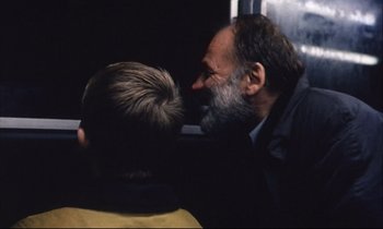 Movie still from “Eternity and a Day” (1998), directed by Theodoros Angelopoulos – A man with a beard is kissing another man's face; Close Up shot, Over the shoulder angle