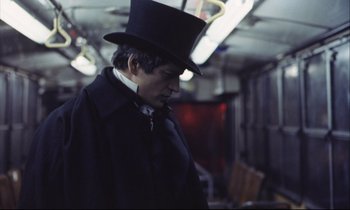 Movie still from “Eternity and a Day” (1998), directed by Theodoros Angelopoulos – A man wearing a top hat and a black coat; Medium shot, Low angle