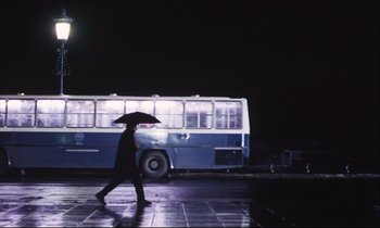 Movie still from “Eternity and a Day” (1998), directed by Theodoros Angelopoulos – A man walking on the sidewalk with an umbrella; Extreme Wide shot, Low angle