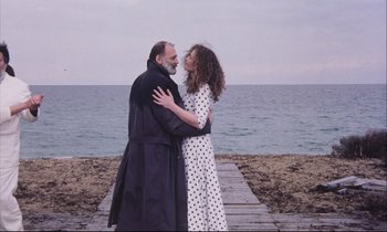 Movie still from “Eternity and a Day” (1998), directed by Theodoros Angelopoulos – A man and a woman embracing on a pier; Medium shot, Low angle