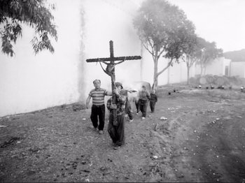 Movie still from “Even Dwarfs Started Small” (1970), directed by Werner Herzog – A group of people walking down a dirt road; Wide shot, Low angle