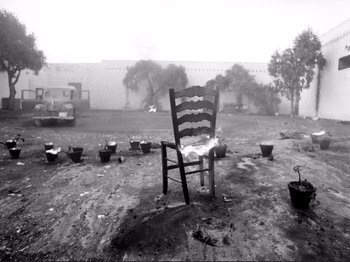 Movie still from “Even Dwarfs Started Small” (1970), directed by Werner Herzog – An empty chair in the middle of an empty field; Wide shot, High angle