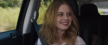 Movie still from “Every Day” (2018), directed by Michael Sucsy – A young girl sitting in the back seat of a car; Close Up shot, Over the shoulder angle