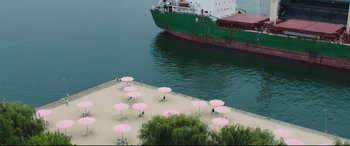 Movie still from “Every Day” (2018), directed by Michael Sucsy – Many pink umbrellas on the beach; Extreme Wide shot, High angle