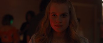 Movie still from “Every Day” (2018), directed by Michael Sucsy – A young girl with long blonde hair is lit up by a red light; Close Up shot, Over the shoulder angle