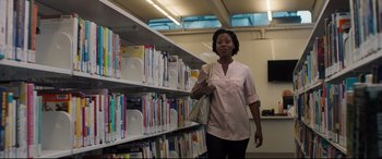 Movie still from “Every Day” (2018), directed by Michael Sucsy – A woman is standing in front of a book shelf; Medium shot, Low angle
