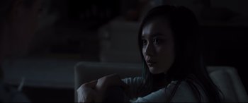 Movie still from “Every Day” (2018), directed by Michael Sucsy – A woman sitting on a couch in a dark room; Close Up shot, Low angle