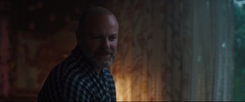 Movie still from “Every Day” (2018), directed by Michael Sucsy – A man with a goatee is smiling for the camera; Close Up shot, Over the shoulder angle