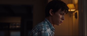 Movie still from “Every Day” (2018), directed by Michael Sucsy – A young boy in a plaid shirt is looking at the camera; Close Up shot, Over the shoulder angle