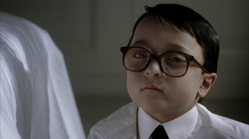 Movie still from “Everything Is Illuminated” (2005), directed by Liev Schreiber – A young boy wearing glasses and a white shirt; Close Up shot, Over the shoulder angle
