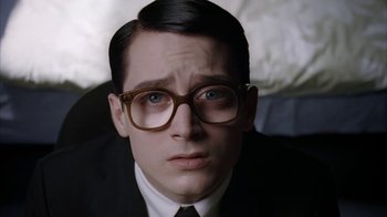 Movie still from “Everything Is Illuminated” (2005), directed by Liev Schreiber – A person wearing a suit and glasses; Close Up shot, High angle
