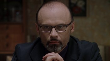 Movie still from “Everything Is Illuminated” (2005), directed by Liev Schreiber – A man with a beard wearing glasses and a suit; Close Up shot, Over the shoulder angle