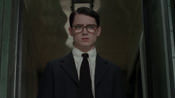 Movie still from “Everything Is Illuminated” (2005), directed by Liev Schreiber – A man in a suit and tie wearing glasses; Close Up shot, Low angle