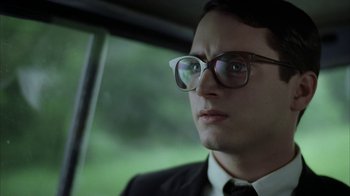 Movie still from “Everything Is Illuminated” (2005), directed by Liev Schreiber – A man wearing glasses and a suit and tie in a car; Close Up shot, Low angle