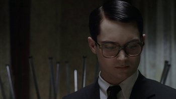 Movie still from “Everything Is Illuminated” (2005), directed by Liev Schreiber – A man in a suit and tie wearing glasses; Close Up shot, Over the shoulder angle
