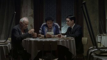 Movie still from “Everything Is Illuminated” (2005), directed by Liev Schreiber – A group of people sitting at a table with cards; Medium shot, High angle