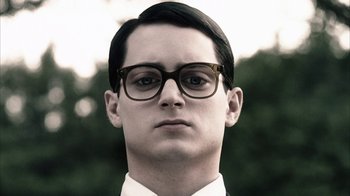 Movie still from “Everything Is Illuminated” (2005), directed by Liev Schreiber – A young man wearing glasses and a white shirt; Close Up shot, Low angle