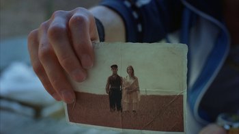 Movie still from “Everything Is Illuminated” (2005), directed by Liev Schreiber – A person holding a picture of a man and a woman; Extreme Close Up shot, Overhead angle