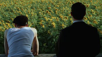 Movie still from “Everything Is Illuminated” (2005), directed by Liev Schreiber – Two men are looking at a field of sunflowers; Medium shot, Over the shoulder angle