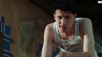 Movie still from “Everything Is Illuminated” (2005), directed by Liev Schreiber – A young man wearing a hat and holding a glass of beer; Close Up shot, Low angle