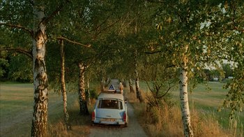 Movie still from “Everything Is Illuminated” (2005), directed by Liev Schreiber – A couple of cars parked on top of a dirt road; Extreme Wide shot, High angle