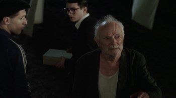 Movie still from “Everything Is Illuminated” (2005), directed by Liev Schreiber – An older man and a younger man in a dark room; Medium shot, Over the shoulder angle