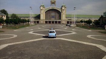 Movie still from “Everything Is Illuminated” (2005), directed by Liev Schreiber – A car parked in front of an old train station; Extreme Wide shot, High angle