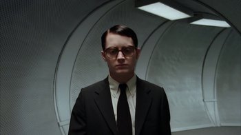 Movie still from “Everything Is Illuminated” (2005), directed by Liev Schreiber – A man wearing a suit and tie standing in a room; Medium shot, Low angle