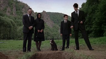Movie still from “Everything Is Illuminated” (2005), directed by Liev Schreiber – A group of people standing around a dog in the grass; Wide shot, High angle