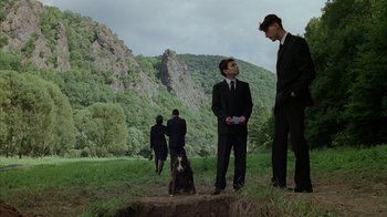 Movie still from “Everything Is Illuminated” (2005), directed by Liev Schreiber – A group of people in suits standing in a field; Wide shot, Low angle