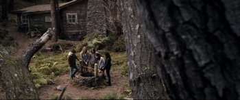 Movie still from “Evil Dead” (2013), directed by Fede Alvarez – A group of people standing next to a tree trunk; Wide shot, High angle