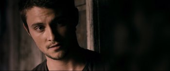 Movie still from “Evil Dead” (2013), directed by Fede Alvarez – A man's face in a dark room; Close Up shot, Over the shoulder angle