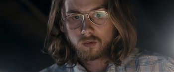 Movie still from “Evil Dead” (2013), directed by Fede Alvarez – A person wearing glasses with long hair; Close Up shot, Low angle