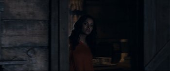 Movie still from “Evil Dead” (2013), directed by Fede Alvarez – A woman standing in a dark room looking at the camera; Medium shot, Over the shoulder angle