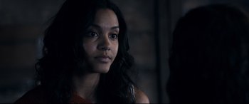 Movie still from “Evil Dead” (2013), directed by Fede Alvarez – A woman with long black curly hair looking at the camera; Close Up shot, Over the shoulder angle