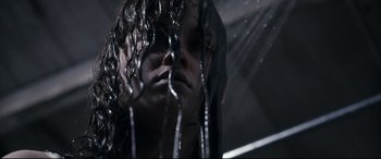 Movie still from “Evil Dead” (2013), directed by Fede Alvarez – A person with long hair is standing in the rain; Close Up shot, Low angle