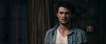 Movie still from “Evil Dead” (2013), directed by Fede Alvarez – A man in a white t - shirt and a jean jacket; Close Up shot, Over the shoulder angle