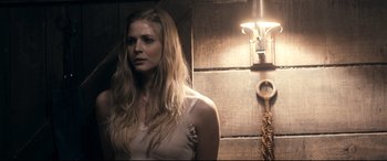 Movie still from “Evil Dead” (2013), directed by Fede Alvarez – A woman standing next to a wall in a room; Close Up shot, Over the shoulder angle