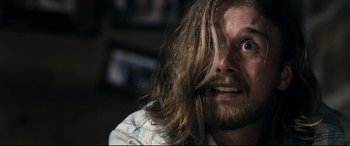 Movie still from “Evil Dead” (2013), directed by Fede Alvarez – A person with long hair; Close Up shot, Over the shoulder angle